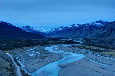 Scenic view of snowcapped mountains against blue sky