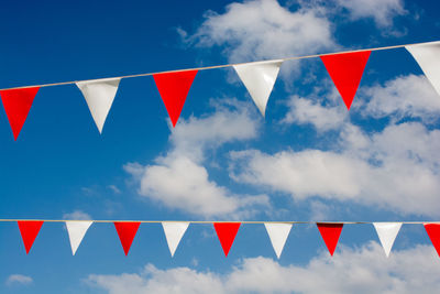 Low angle view of flags against sky