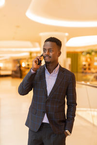 Portrait of young man standing in office