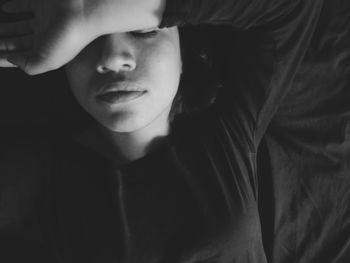 Close-up of young woman relaxing on bed