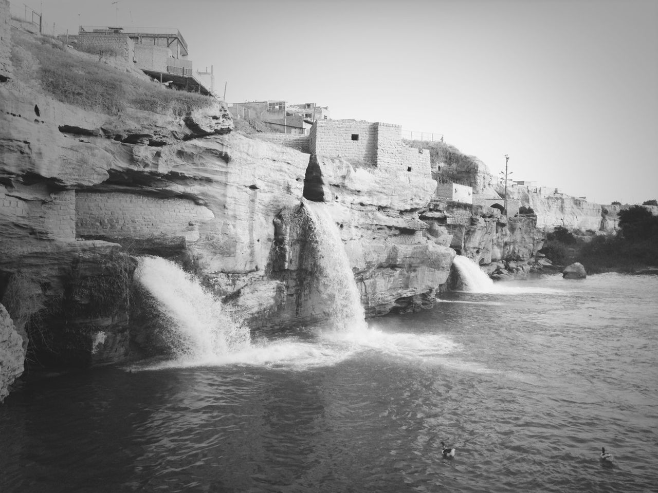 water, rock - object, rock formation, clear sky, sea, waterfront, cliff, scenics, beauty in nature, nature, built structure, architecture, building exterior, rock, motion, tranquil scene, day, tranquility, surf, outdoors