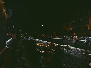 Illuminated buildings by street in city at night