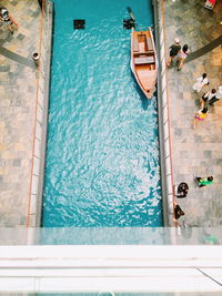 Directly above shot of people by blue canal in city