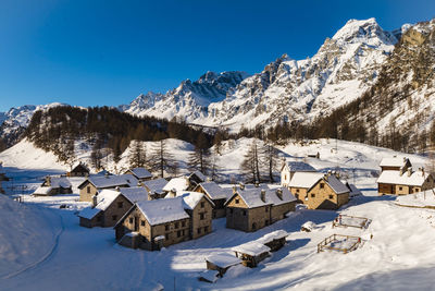 Panoramic view of snow covered landscape against blue sky