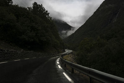 Road leading towards mountain against sky