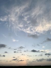 Low angle view of sunlight streaming through clouds