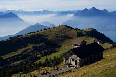 Houses on field by mountains against sky