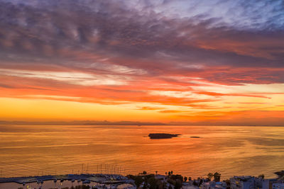 Scenic view of sea against dramatic sky during sunset