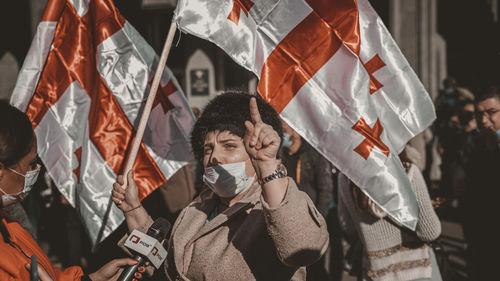 Low section of woman holding flag in city