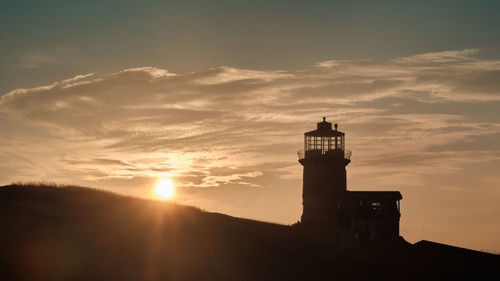 Silhouette lighthouse against sky during sunset