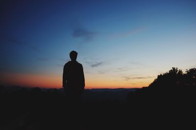 Silhouette man standing against blue sky