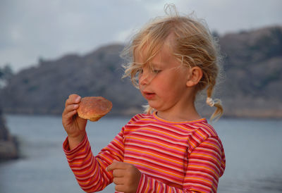 Cute girl holding animal shell at beach