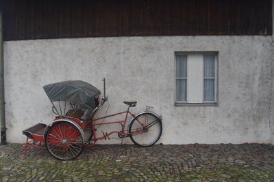 Bicycle parked against wall of building