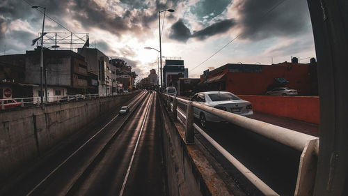 Railroad tracks amidst buildings in city against sky