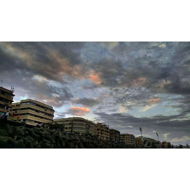 architecture, building exterior, built structure, sky, transfer print, cloud - sky, city, cloudy, auto post production filter, low angle view, overcast, cloud, tower, sunset, building, dusk, weather, silhouette, cityscape, outdoors