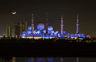 Illuminated buildings against sky at night