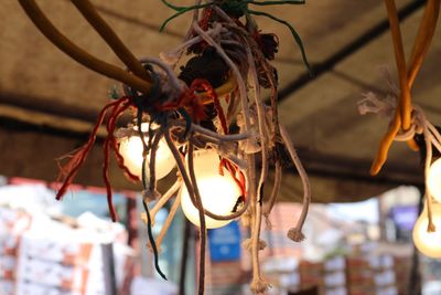 A cluster of wires and lights under a market tent