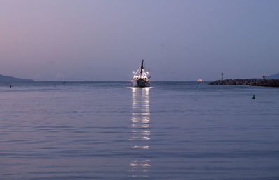 Sailboat in sea against clear sky