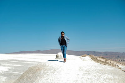 Full length of woman against blue sky on sunny day