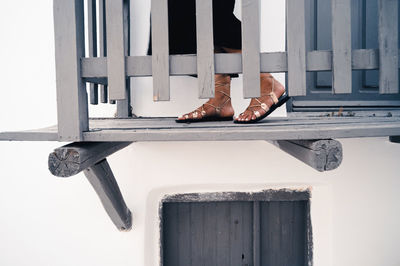 Low section of woman standing by window