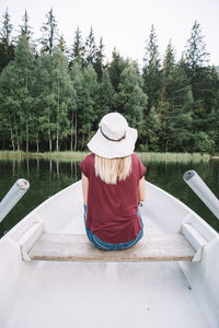 Rear view of woman in hat against lake