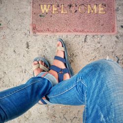 Low section of man sitting by doormat