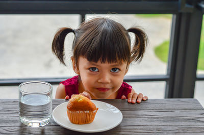 Portrait of cute boy with ice cream on table