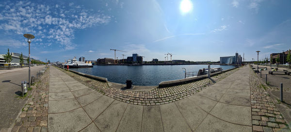 Panoramic view of city by river against sky