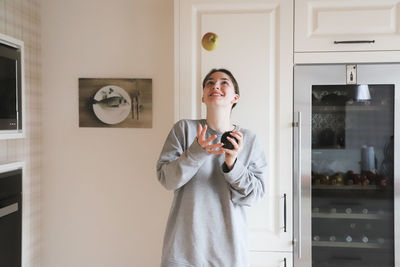 Young woman standing at home