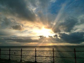 Scenic view of sea against cloudy sky during sunset