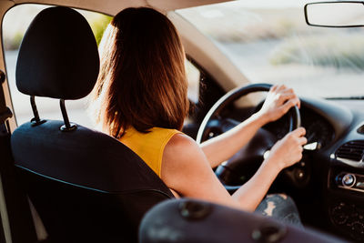 Rear view of woman sitting in car