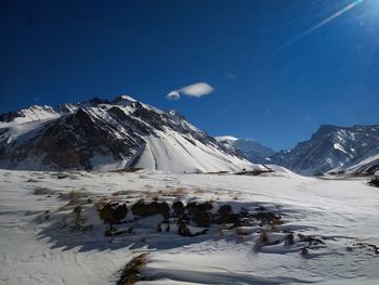 Scenic view of snowcapped mountains against blue sky