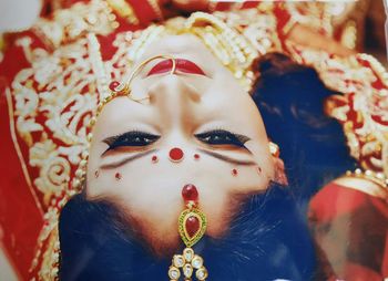 Directly above shot of bride wearing red wedding dress with make-up and jewelries