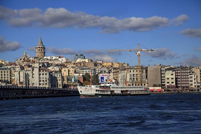 Sea by buildings against sky in city