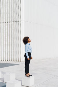 Afro businesswoman standing on concrete block