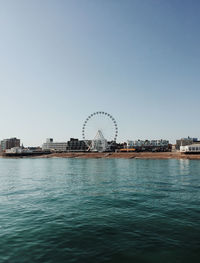 Ferris wheel in city against clear sky