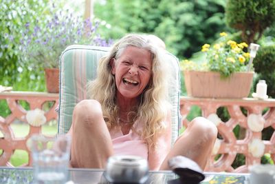 Cheerful mature woman sitting on porch