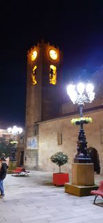 Illuminated street light on building during winter at night