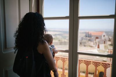 Mother with son looking through window