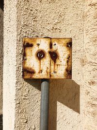 Close-up of old rusty mounted on wall