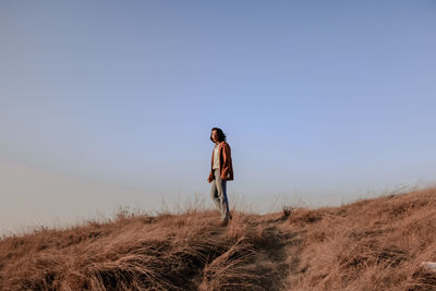 Man standing on field against clear sky