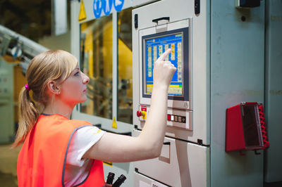 Woman in reflective clothing working at factory