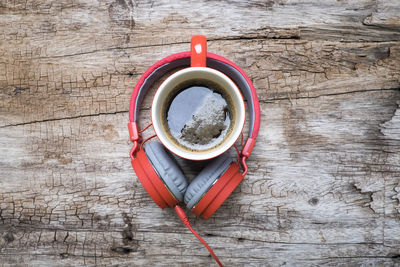 Directly above shot of headphones with coffee cup on wooden table