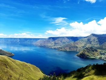 Scenic view of lake and mountains against blue sky