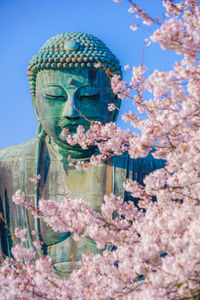 Statue of cherry blossom against clear sky