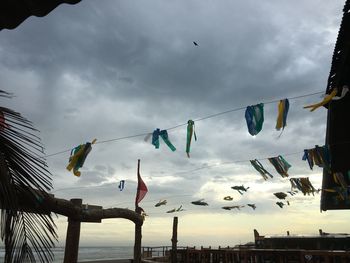 Low angle view of flags hanging against sky