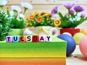 Close-up of colorful blocks with tuesday text on stacked papers over table