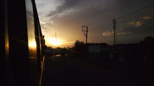 Silhouette railroad tracks against sky during sunset