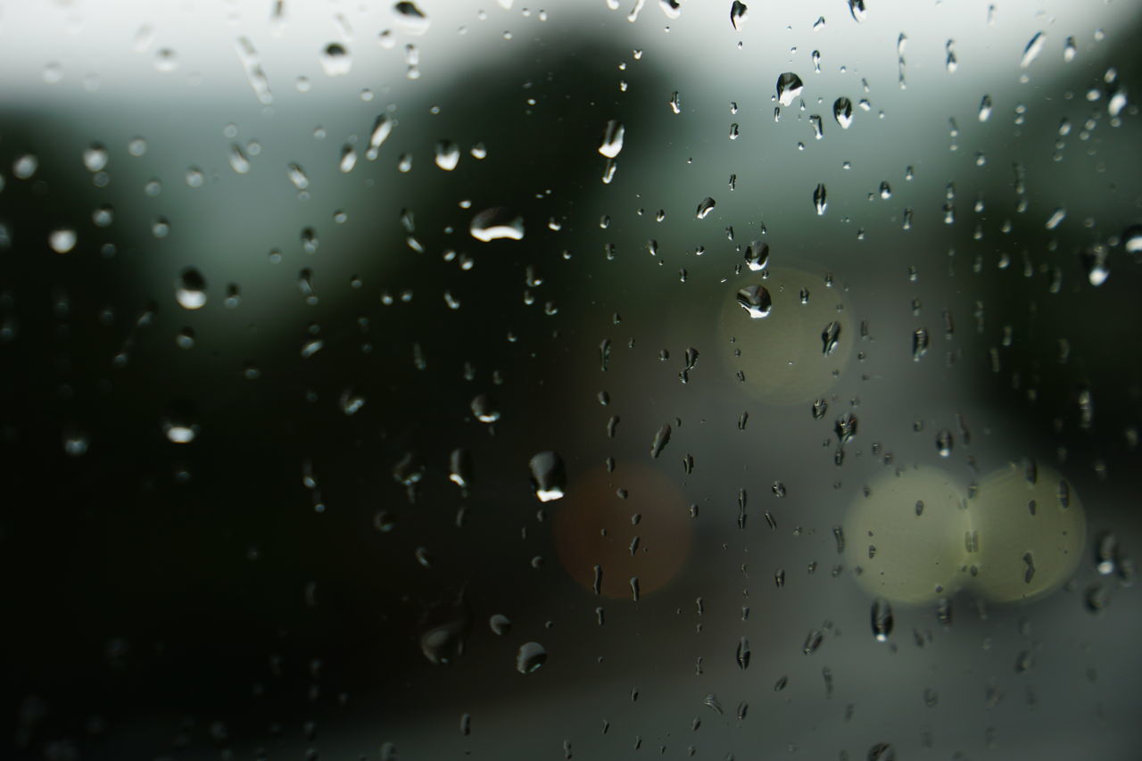 CLOSE-UP OF WET GLASS WINDOW DURING RAINY SEASON