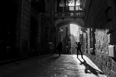 People walking on footpath amidst buildings in city